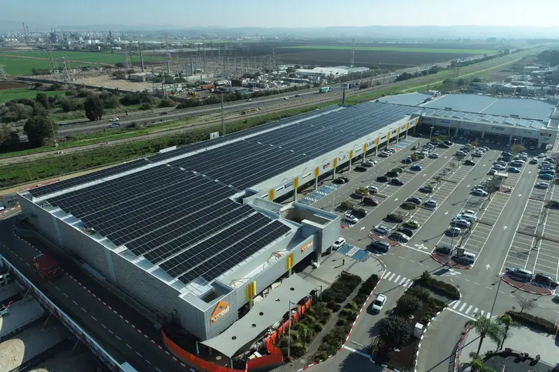Grande edificio con la copertura interamente occupata da moduli fotovoltaici